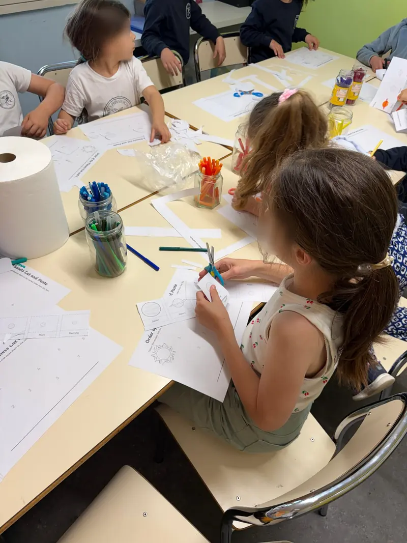 Des enfants découpent et classent les planètes du système solaire, fiche en anglais