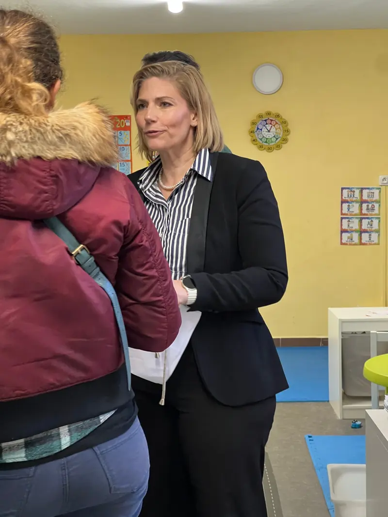 Pernille Kongstad, directrice, échange avec une mère dans une classe aux murs jaunes