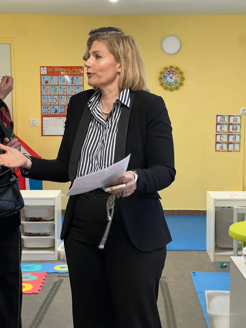 Pernille Kongstad, directrice, parle aux familles dans une classe de maternelle, une feuille à la main