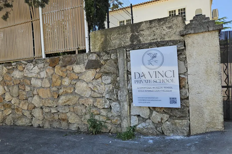 The school gate, with the Da Vinci Private School sign on the stone wall