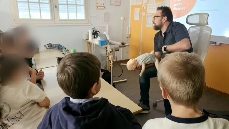 The trainer holding a baby manikin face down along his forearm, the position used to help a choking baby